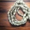 Person using a Tulasi Japa Mala for meditation, counting mantras and deepening their spiritual practice.