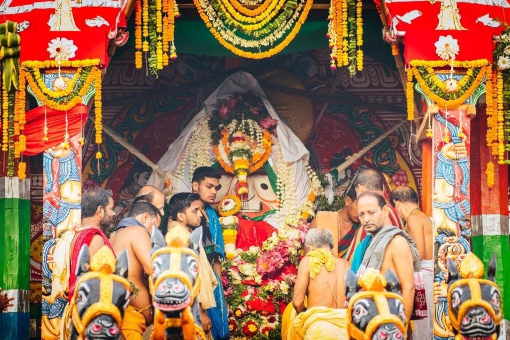 Large deity statue surrounded by people and flowers, featured in the Brahma Taladhwaja article