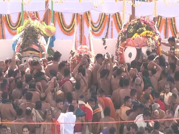 Crowd surrounding two large statues, featured in the Water Abhishekam article