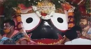 Large decorated face with two eyes and a mouth surrounded by people, illustrating Chitalagi Amavasya