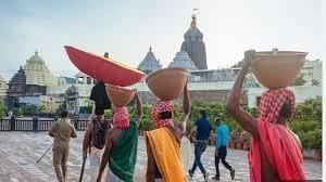 Two people carrying large conical objects on their heads, featured in the Taada article